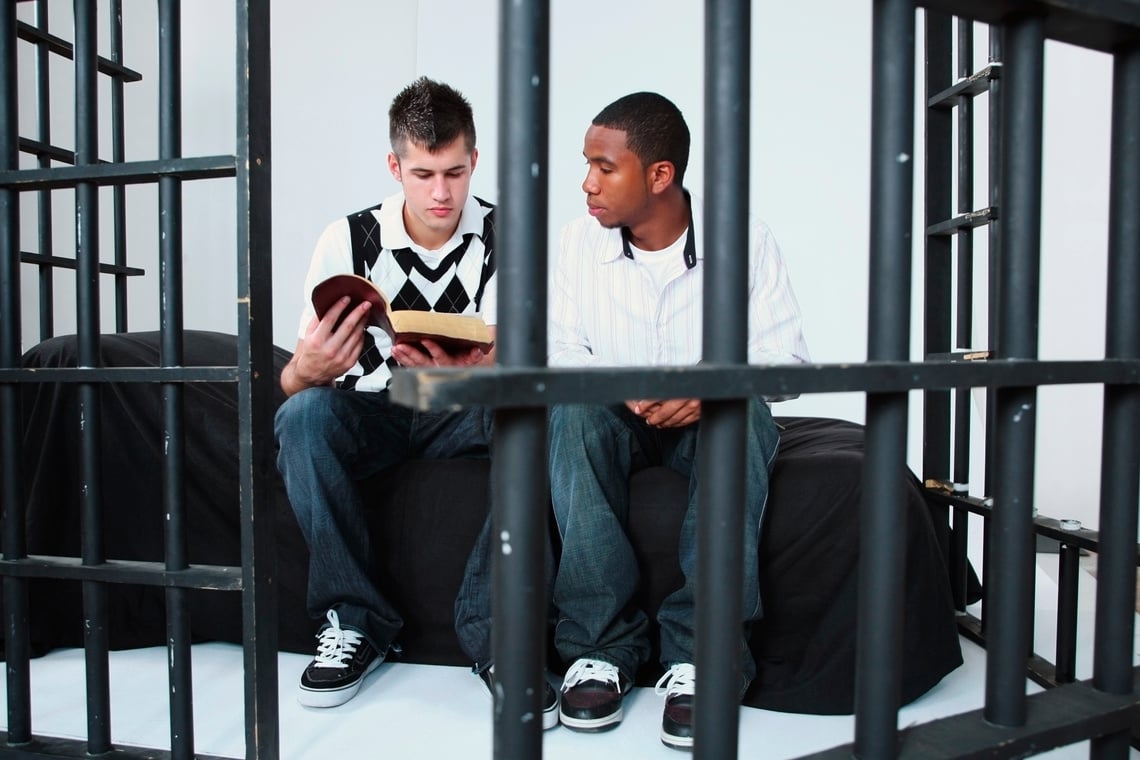 Man Reading Bible to Another Man in Jail